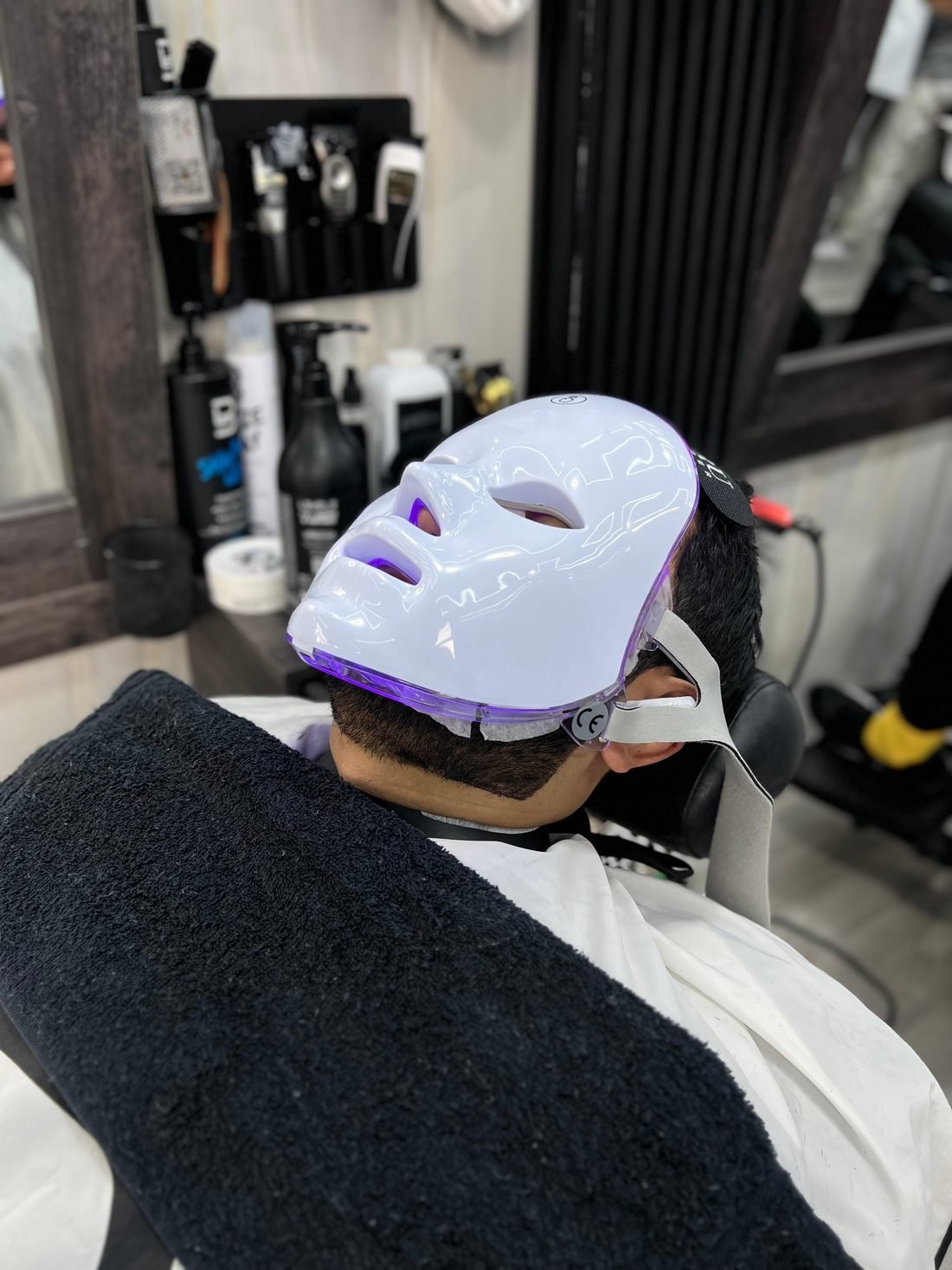 Cliente con mascarilla LED durante una limpieza facial